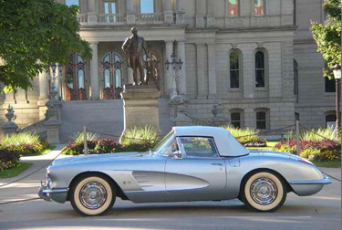 Picture of Patrick and Ellie's 1958 silver/blue Corvette in front of the State Capitol.